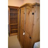 A modern pine arched top wardrobe, 147 x 187cms high; together with a pine open bookcase,
