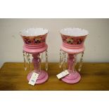 Two pink glass Victorian table lustres, 29cms high.