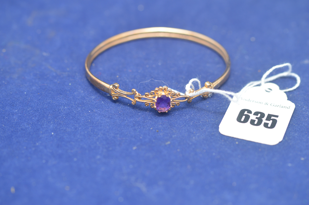 A 9ct. yellow gold bangle set with an amethyst, 6.2grms gross.