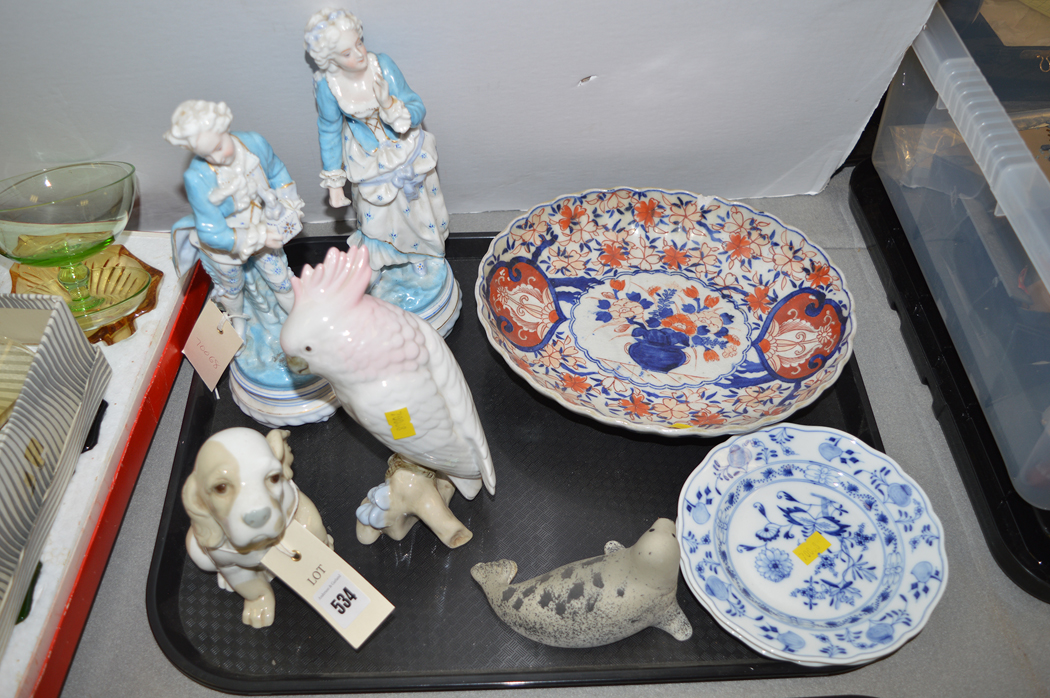 Porcelain figurines of a man and woman with other various items.