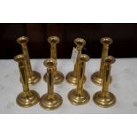 A set of eight modern brass candlesticks.
