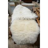 Two double sheepskin rugs; and another rug, probably goatskin.