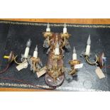 A large ornate cast metal five-branch modern wall light fitting with glass drops,
