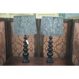 A pair of modern black ceramic table lamps, fitted with guinea fowl feather shades.