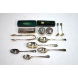 Various silver spoons, sugar tongs, pair of silver topped glass rouge-pots and a nail buffer,