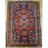 South West Persian Bakhtiari rug, symmetrical stylised floral design on red ground,