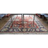 An Indian Agra carpet with large rosettes and scrolling tendril on red ground,