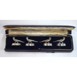 A cased set of four silver menu-card holders, cast with golden pheasants on weighted oval bases,