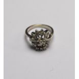 A pierced coronet style ring set with brilliant cut diamond in centre,