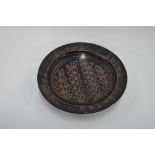 A studio stoneware charger with foliate slip decoration on a black glazed ground,