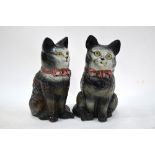 A large pair of Staffordshire pottery seated cats with glass eyes and painted ribbon bow collar,