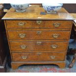 An 18th century and later walnut veneered chest of four long graduated drawers on shaped bracket