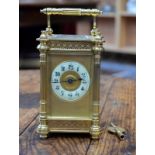 A gilt brass carriage clock with blind-fret tracery friezes and fluted pilaster pillars,