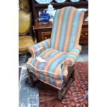 An 18th century style upholstered high back armchair over a bobbin turned under frame,