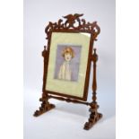 A satinwood-crossband easel photograph frame on turned wood stand with fret-cut decoration,