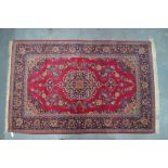 A Persian Kashan rug, the stylised floral design centred by a medallion on red ground, circa 1940's,