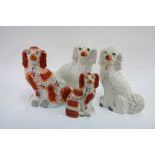 Two pairs of 19th century Staffordshire pottery spaniels (one pair graduated)