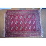 A Turkman rug, last quarter 20th century, three rows of guls on red-brown ground,