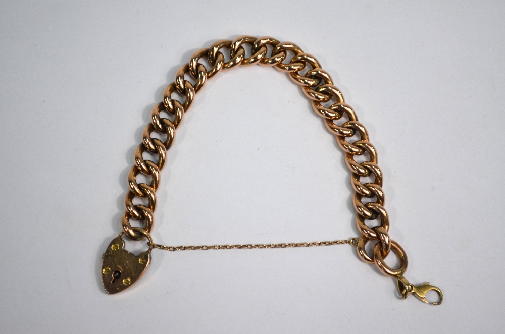 A rose-coloured metal curb bracelet having padlock attached, padlock stamped 9ct,