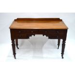 An early Victorian mahogany kneehole writing table with two frieze drawers above two short drawers