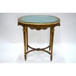 A 19th century giltwood and composite ovoid centre table with glazed inset silk paneled top over a