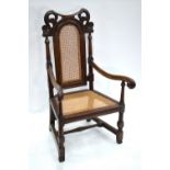 An oak framed cane panelled open armchair in the 17th century style