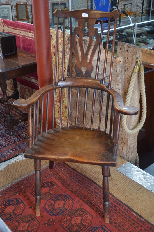 A 19th century elm seat comb back chair with flat arms,