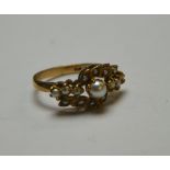 An Edwardian style half pearl set cluster ring,