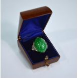 An Edwardian oval green jade cabochon ring, having six eight-cut diamonds on each shoulder,