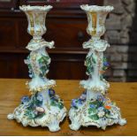 A pair of French 19th century porcelain candlesticks of scrolling rococo form with gilding and