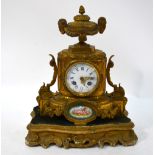 A 19th century gilt metal mantel clock with urn finial above enamel dial and Sevres style oval
