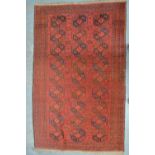 An antique Afghan Turkman design rug, 1st half 20th century, red ground,