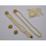 A suite comprising a single row uniform cultured pearl necklace on yellow metal stylised flower