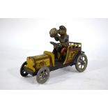 A German tinplate clockwork car, driven by a monkey in top hat, striped jacket and red breeches,