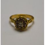 A ruby and diamond cluster ring in partly textured yellow metal setting stamped 18ct