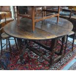 An 18th century oak gateleg dining table, the ovoid drop leaf top raised on a jointed oak frame,