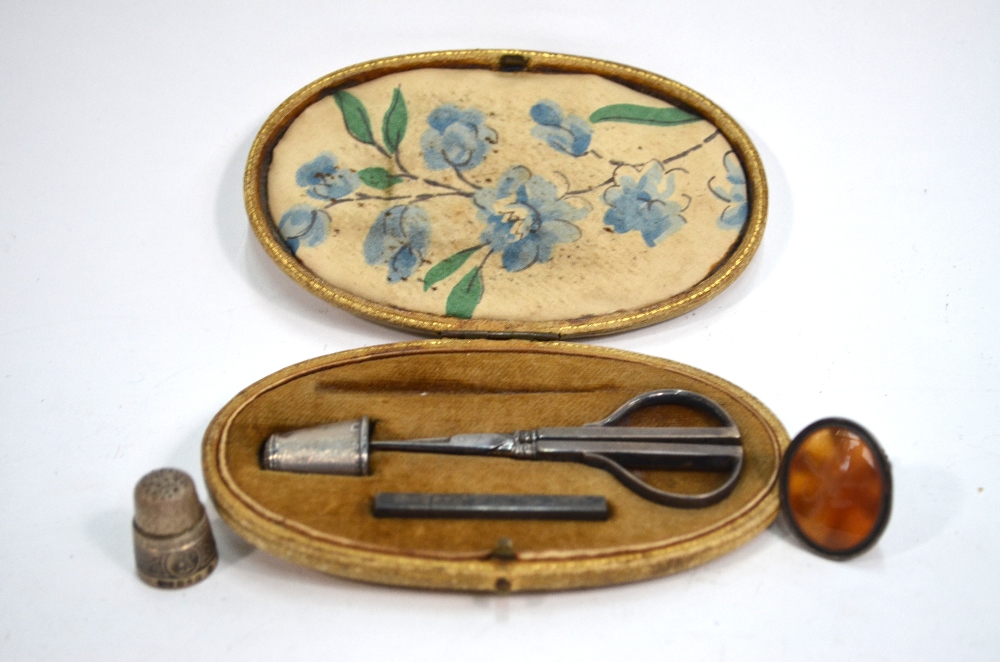A leather-cased necessaire, containing a pair of silver mounted scissors and a needle-case,