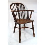 A 19th century yew and elm Windsor elbow chair raised over a crinoline stretcher