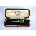 A green jade oval cabochon and diamond cluster style brooch on white metal bar,
