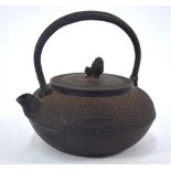 A Japanese shibui metal tetsubin with looped handle, cover and finial; 12 cm high,