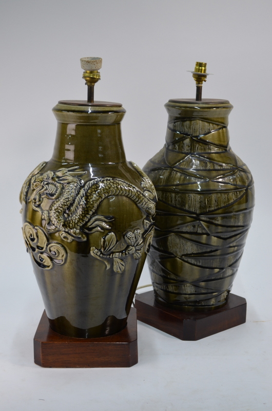 Two olive green monochrome vases decorated in the Chinese style, both mounted for electricity,