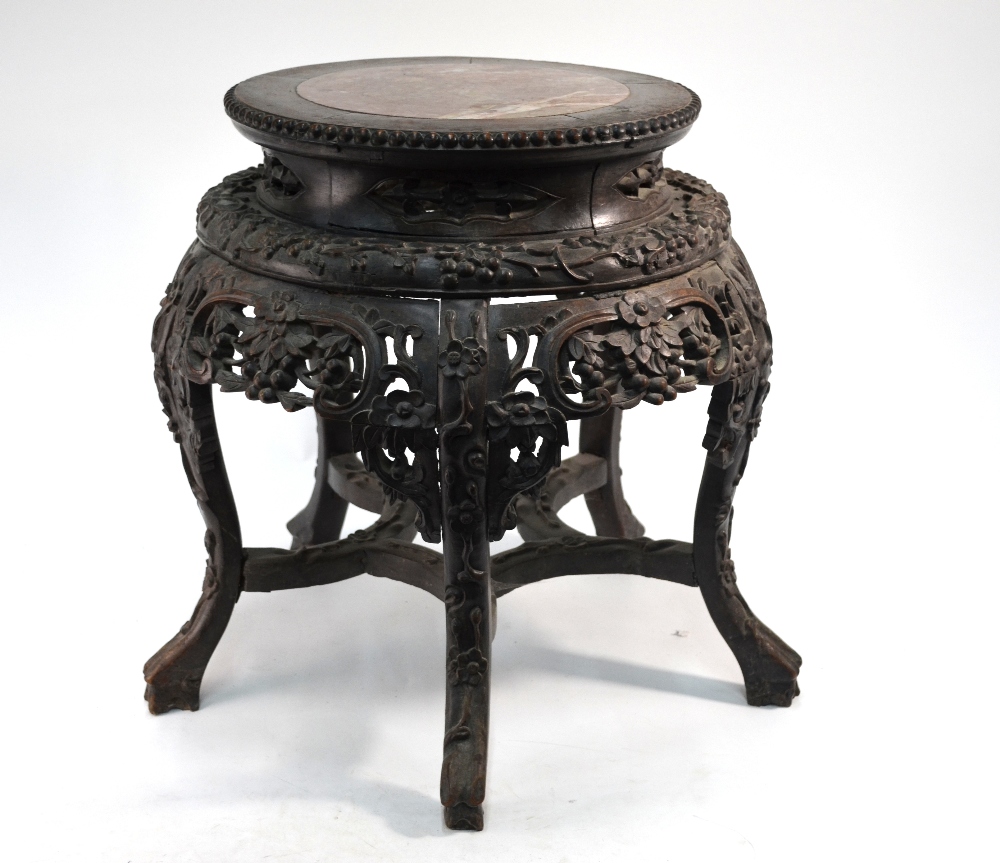 A Chinese wood and marble (or other stone) stand of typical cylindrical and reticulated form,