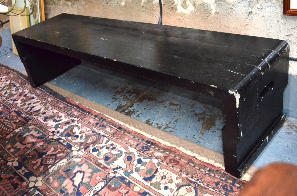 A Chinese ebonised low table or bench with pierced end handles, 160 cm long x 39.