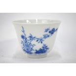 A Chinese blue and white month cup decorated with a floral design and a poetic,