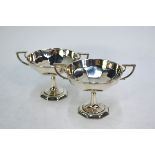 A pair of silver bonbon comports with twin handles, tapering stems and octagonal bases, S W