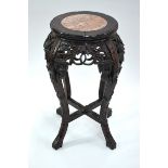 A Chinese hardwood stand on four flaring feet with circular marble, or other stone, inlaid top;