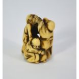 An ivory netsuke carved as three blind masseurs (amma) fighting with each other, 4cm high, unsigned,