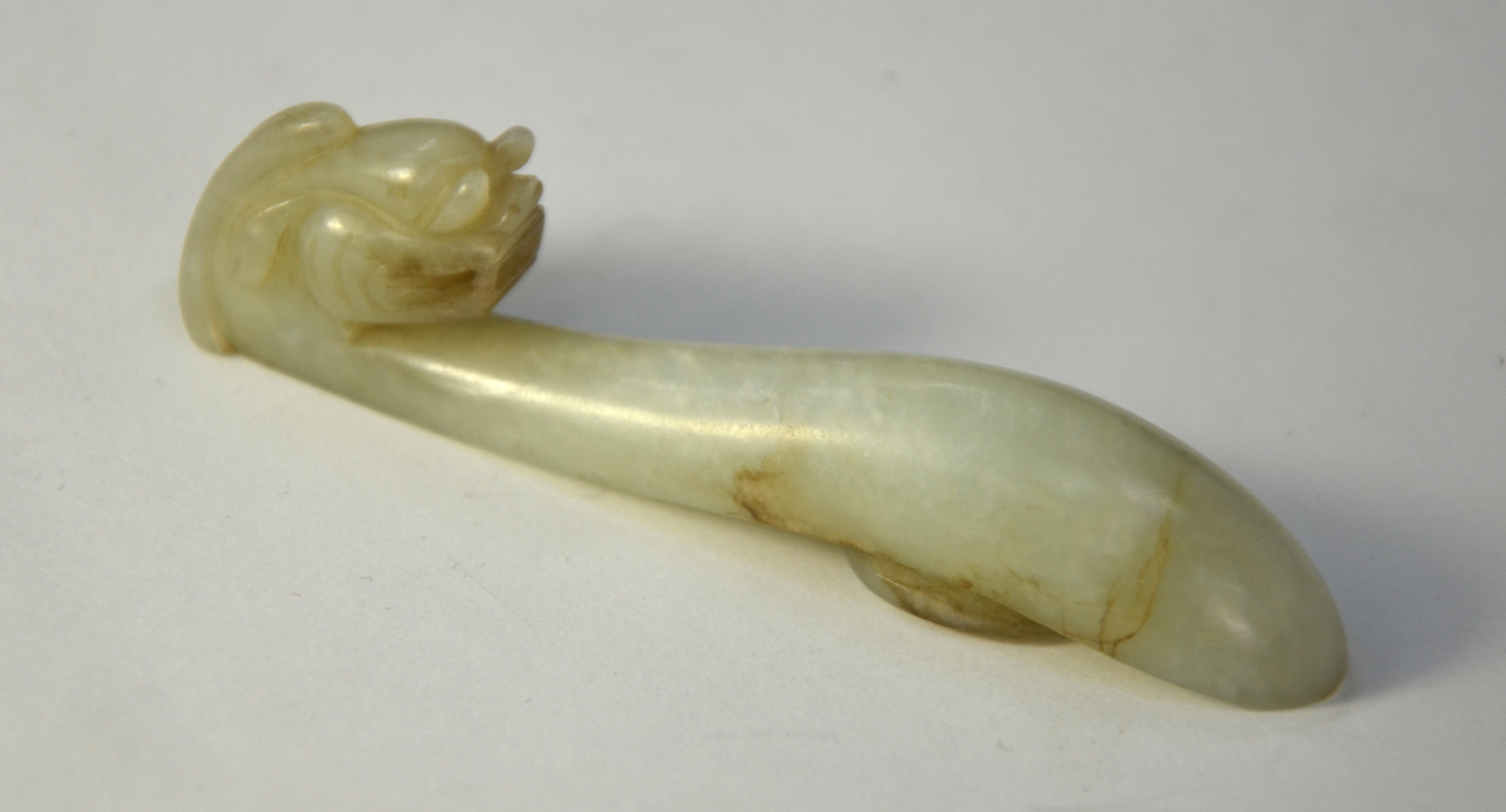 A mottled jade belt hook with mythological animal head and oval boss; 8.5 cm long, Qing Dynasty or - Image 2 of 6