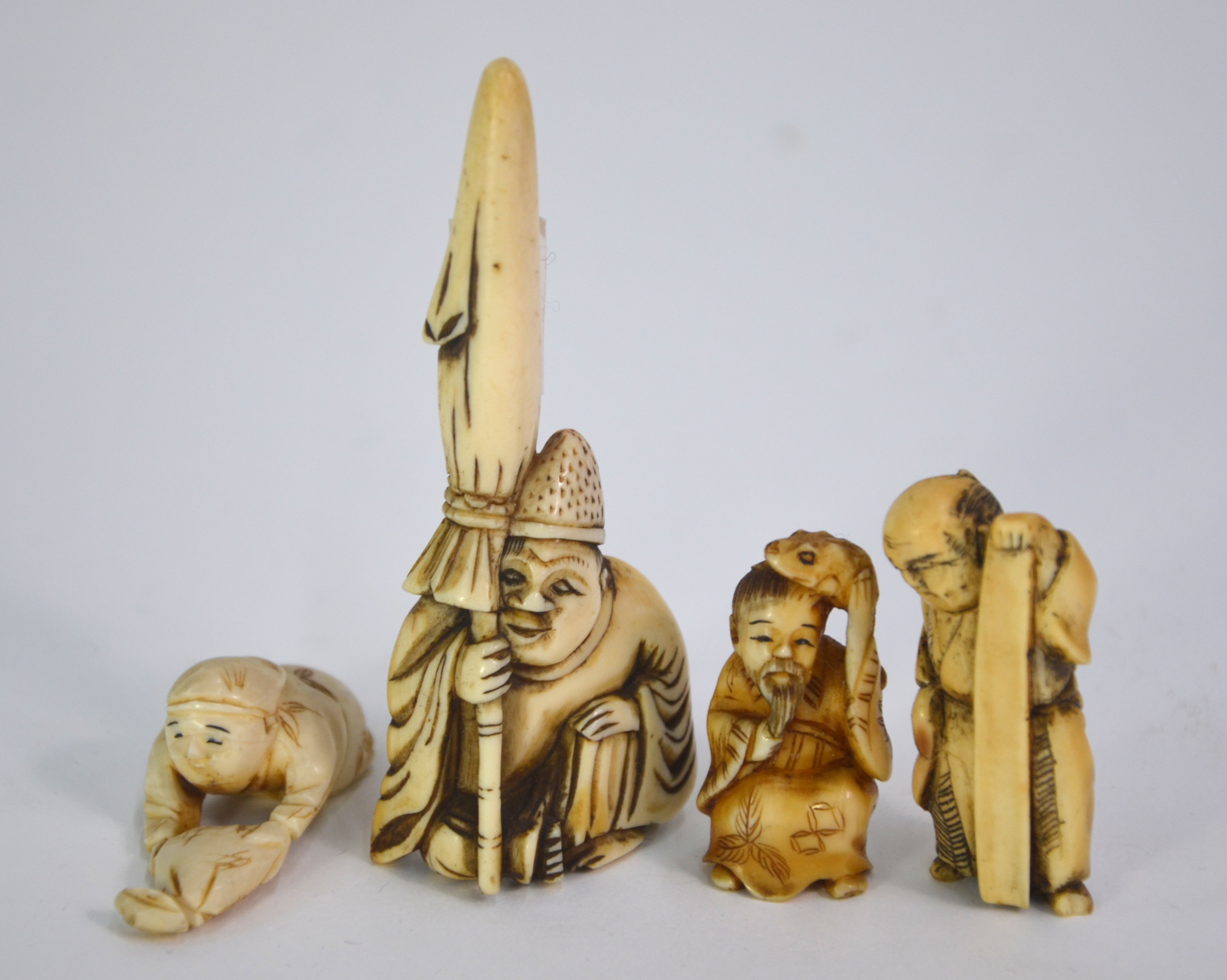 Seven ivory netsuke, including: one of Jurojin holding a makemono; and one of Gama Sennin holding - Image 6 of 9