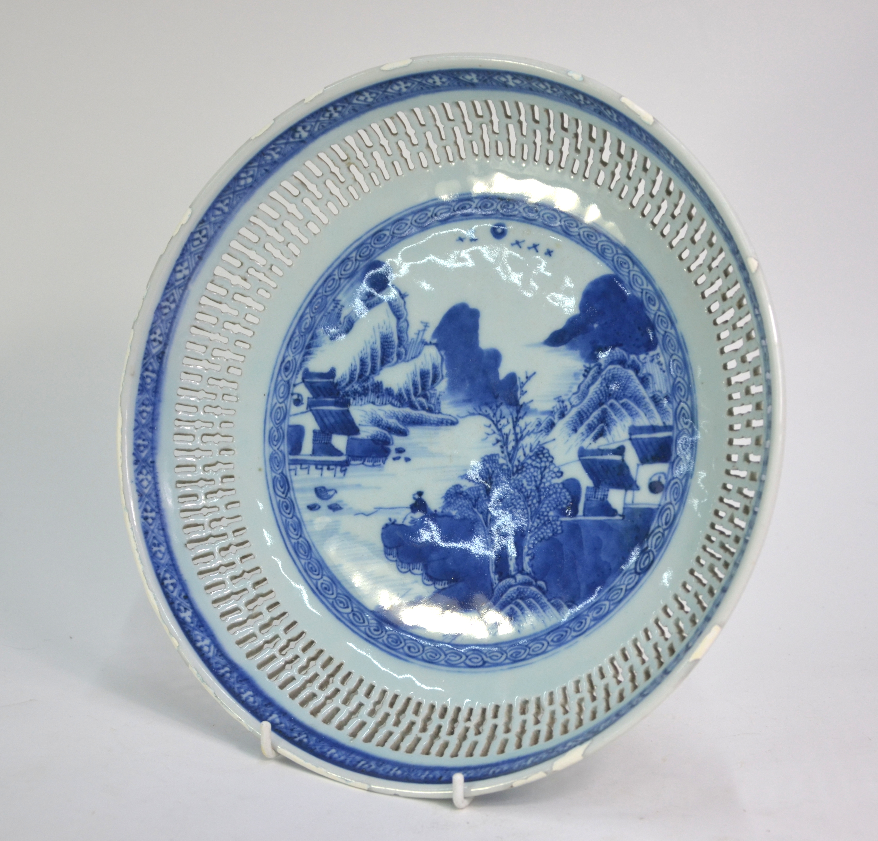 A blue and white dish of circular form with reticulated rim; decorated with a fisherman in a